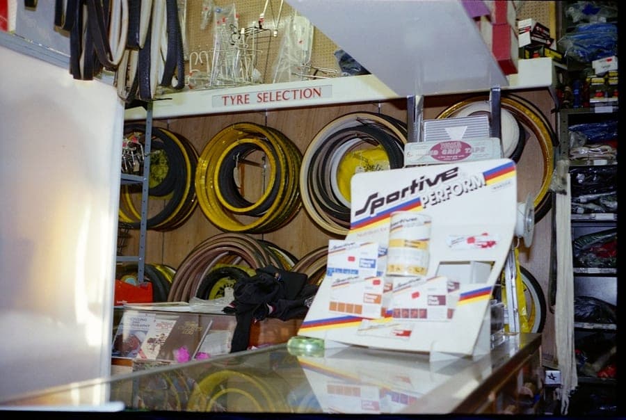 A wall headed 'TYRE SELECTION' with tubular tyres coiled in rows above the glass counter.