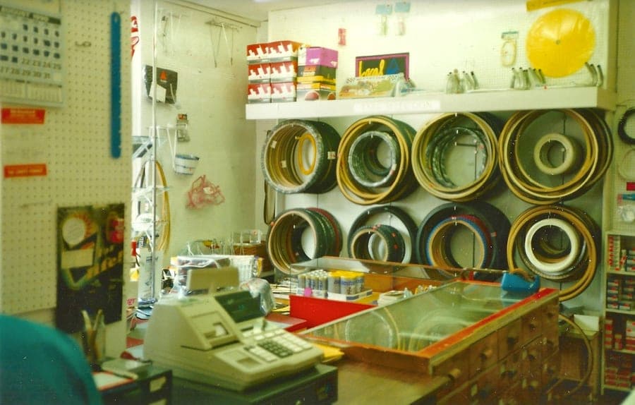 The counter, rims hung in rows on the pegboard behind it and a mechanical till standing on the glass top.
